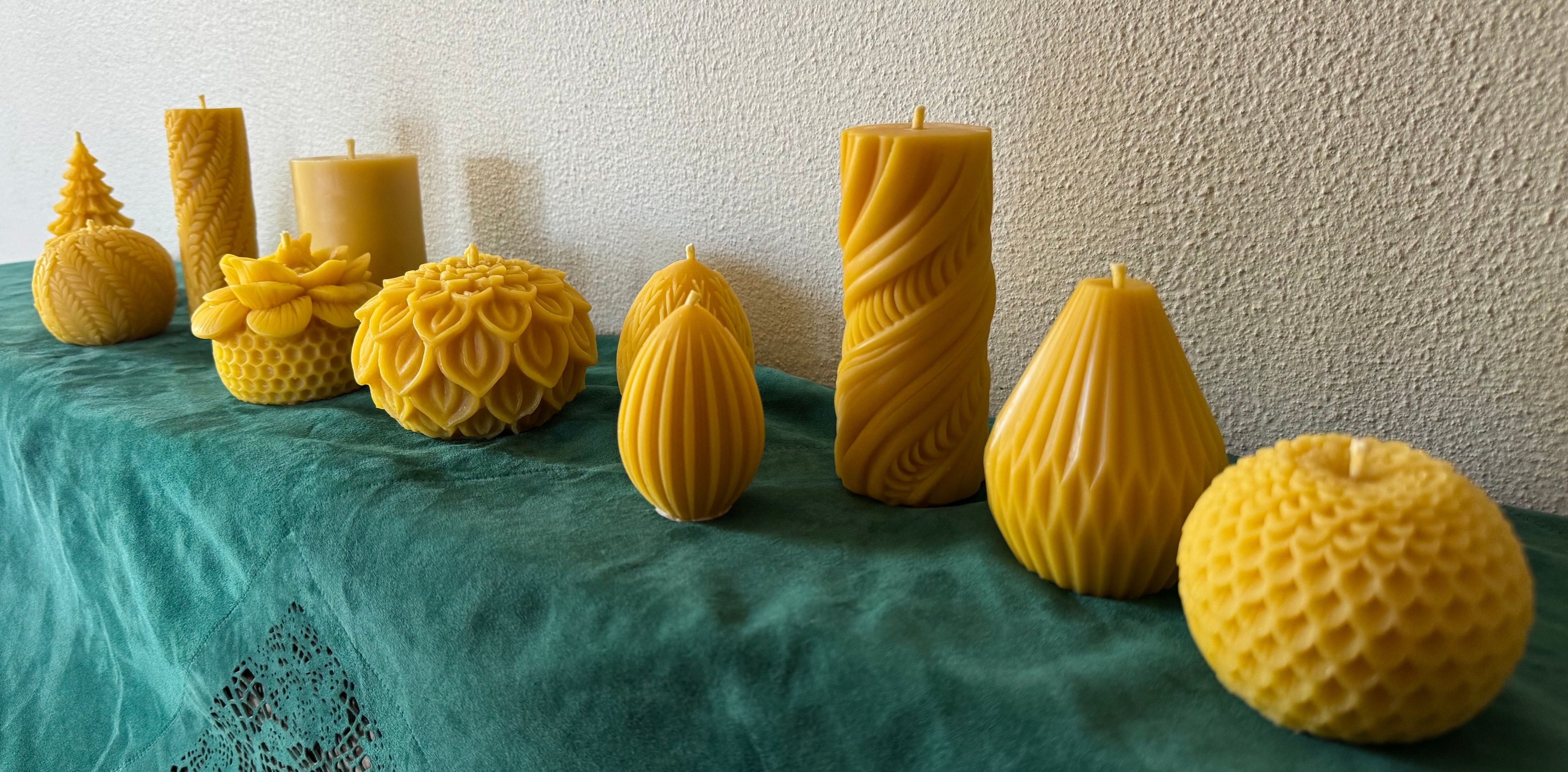 Full range of Little Bee beeswax candles arranged on a teal cloth